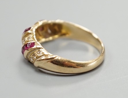 A modern 585 yellow metal, ruby and diamond chip set half hoop ring, size M/N, gross weight 3.3 grams.